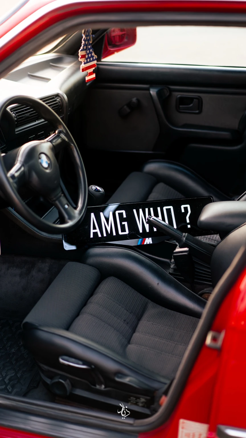 AMG WHO plate inside a red BMW